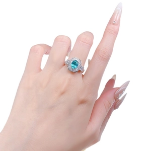 Bague en argent 925 avec tourmaline Paraïba 1,5ct et halo géométrique portée à la main