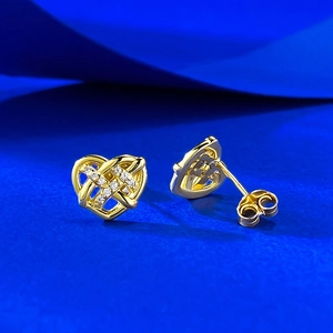 Macro shot of gold S925 silver woven heart stud earrings with sparkling cubic zirconia