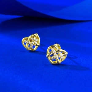 Detailed macro view of gold heart-shaped woven earrings with micro-set crystals