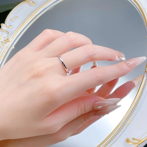 Close-up of minimalist 925 silver ring on model finger reflecting in a white mirror