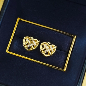 Elegant gold heart-shaped woven earrings with sparkling zircon pavé on blue velvet
