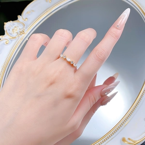 Detail shot of a hand wearing a gold marquise and round cut zircon silver ring