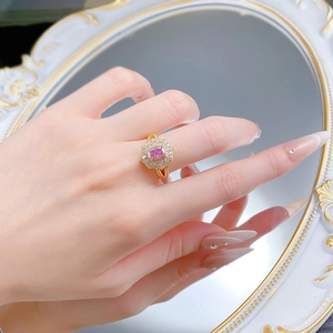 Détail de la bague en or luxueuse avec pierre rose taille coussin et halo de diamants