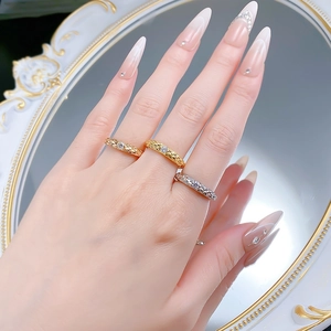 Detailed view of three stackable rings with textured mesh pattern and sparkling stones