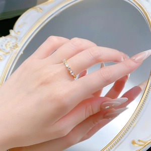 Detail of gold marquise and round zircon ring reflected in vintage mirror