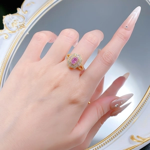 Gros plan d'une bague en argent 925 avec diamant rose ovale et finition dorée au doigt