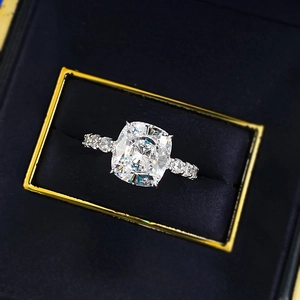 Macro shot of cushion cut diamond ring in a premium black and gold velvet jewelry box