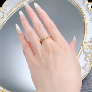 Detailed view of gold woven dragon scale ring with round clear moissanite on finger
