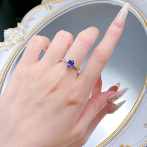 Close-up of elegant S925 silver ring with oval blue sapphire and side micro-diamonds