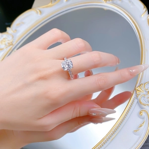 Macro view of cushion cut high carbon diamond ring with silver band on hand