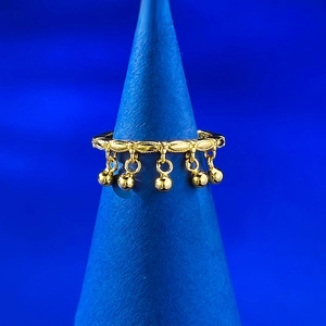 Detailed view of a gold-plated tassel ring featuring five solid metal charms on a blue stand