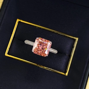 Gros plan d'une bague avec pierre rose 9mm taillée radiant en argent S925 en boîte