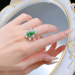 Close-up of a vintage 925 silver ring featuring a green pear-cut stone and white pearls