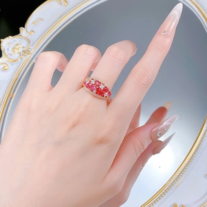 Detail of red zircon ring with micro-pave diamonds on hand against vintage mirror