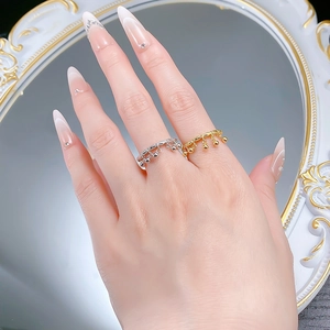 Detailed view of S925 silver bell tassel rings in gold and silver on fingers