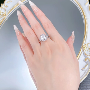 Close-up of S925 silver emerald-cut diamond ring with rectangular side stones on hand