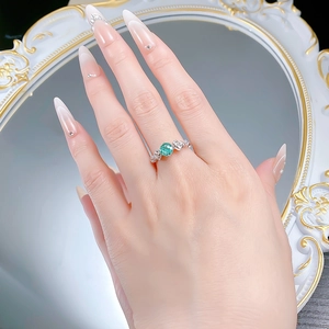 Close-up of S925 silver ring with 6mm Paraiba blue round stone on model's hand