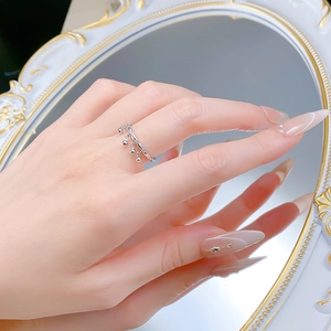 Close-up of S925 sterling silver ring featuring delicate bell tassels and crown design