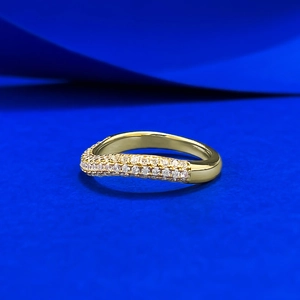 Elegant gold wavy band ring with double row micro-pave crystals on blue background