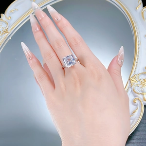 Macro shot of 925 silver ring with emerald cut white diamond on female hand