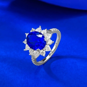 Macro shot of S925 silver ring featuring oval blue gemstone and halo of clear zircons