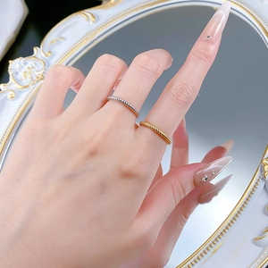 Close-up of 925 sterling silver twisted rope rings in gold and silver finish on hand