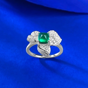 Gros plan d'une bague en argent S925 avec émeraude carrée et pétales sertis de diamants