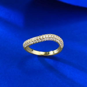 Macro detail of S925 sterling silver gold-plated wavy ring with pavé-set crystals