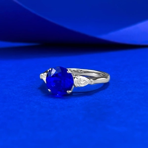Detailed close-up of 8mm blue spinel ring with side pear-shaped accent diamonds