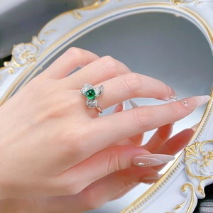 Détail macro de la bague en argent S925 avec émeraude verte et feuilles de diamants