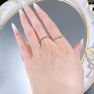 Detail of twisted stackable 925 silver rings in gold and silver finish on hand