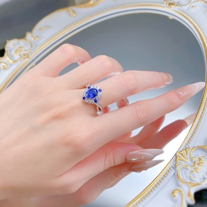 Elegant S925 silver ring with oval blue sapphire and white diamond halo on finger