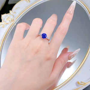 Detail view of 8mm blue spinel S925 silver ring worn by hand reflecting in a mirror