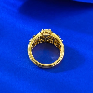 Macro shot of gold ring showing intricate hollow craft and cluster stone settings