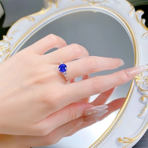 Close-up of 8mm blue spinel ring with pear-shaped side diamonds on a silver band