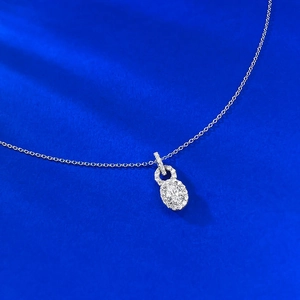 Macro shot of S925 silver necklace with oval diamond lock pendant on blue silk