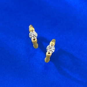 Macro shot of S925 silver gold bamboo earrings with brushed texture and round diamonds