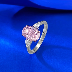 S925 silver ring with 7x10mm oval pink gemstone and pear-cut side stones on blue satin