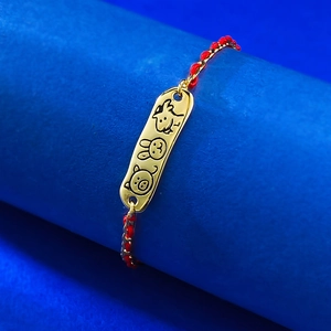 Detail of red braided S925 bracelet featuring a golden zodiac pendant on blue display