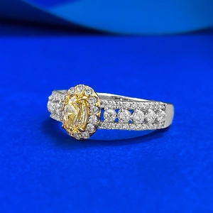 Vue détaillée d'une bague ovale avec gemme jaune, halo et anneau large serti de diamants