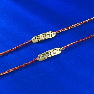 S925 silver red string bracelet with gold zodiac charms on a blue textured surface