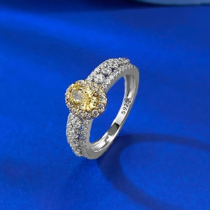 Gros plan d'une bague en argent S925 avec un grand diamant jaune ovale et des zircons pavés