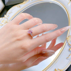 Macro shot of S925 silver ring featuring pink oval gemstone and side pear-shaped stones