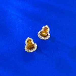 Macro shot of S925 silver gourd studs with tiger eye stone and zircon accents