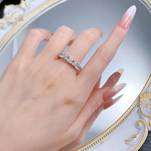Close-up of elegant silver band ring featuring square-cut pavé diamonds on a model's hand