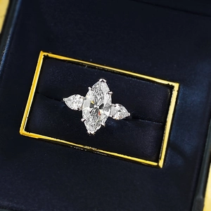 Macro shot of a marquise-cut center stone ring in a navy velvet jewelry gift box
