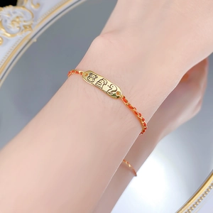 Detailed shot of S925 red braided bracelet with gold zodiac pendant on wrist