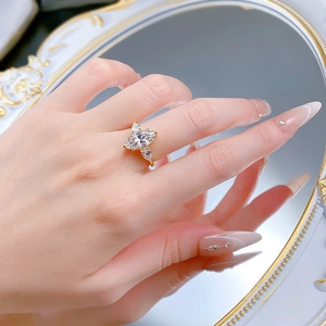 Detailed view of marquise-cut diamond ring on model hand with vintage mirror background