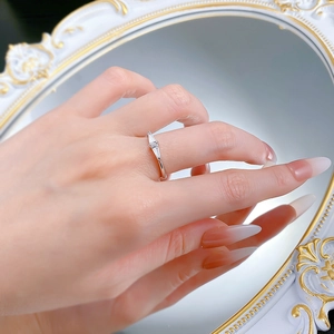 Close-up of minimalist silver ring with baguette-cut stones worn on a finger