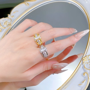 Detailed close-up of luxury gold and silver oval halo rings with pavé set zircon stones